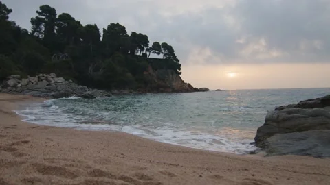 Steady shot at the edge of the wild beach at cloudy sunrise, in Spain Stock Footage 230098090
