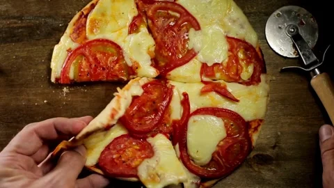 A steady shot shows a cooked mix pizza on a wooden plate while a pizza lifter Video stock 336586676