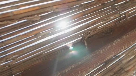 Steady shot of the sun's rays through the thatched roof Stock Footage 108676656
