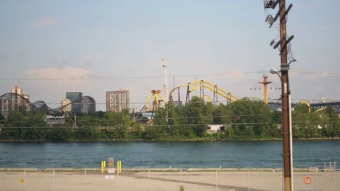 Steady slow motion shot of La Ronde Six Flags amusement park across the river! Stock Footage 79886944