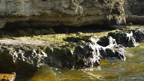 Steady time lapse view on small calm river waves crashing against wet rocks Stock Footage 107332542