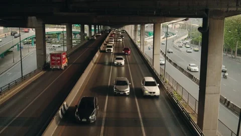 Steady traffic on elevated expressway with parallel roads and concrete pillars Stock Footage 320871614