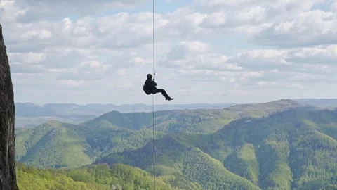 Steady Wide Shot of Climber Slowly Rappelling in Free Hang Stock Footage 345632430