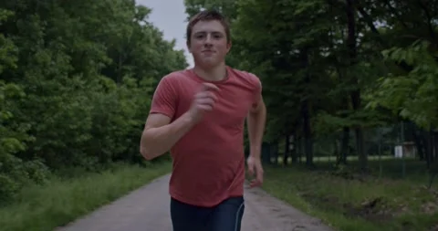 Steadycam shot, half close-up of boy running speeding in the countryside. Stock Footage 131868119