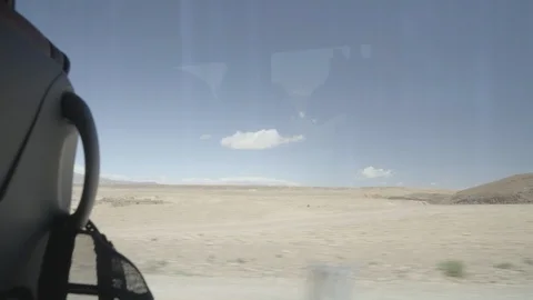 Steadycam shot through a car window driving through desert landscape Stock Footage 100293741