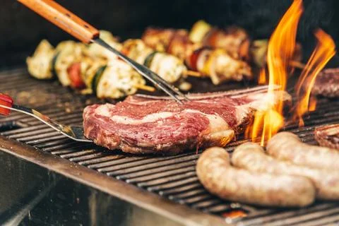 Steak and flames on the grill Stock Photos