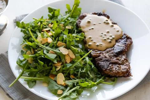 Steak with arugula Stock Photos