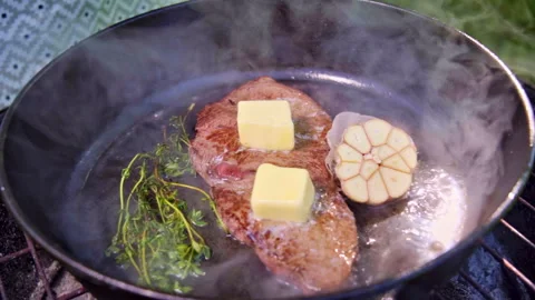 A steak is being cooked with onions, garlic, and thyme. Stock Footage 317932811