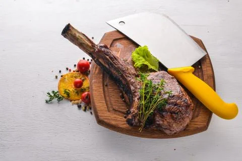Steak on the bone. Top view. Free space for text. On a wooden background. Stock Photos