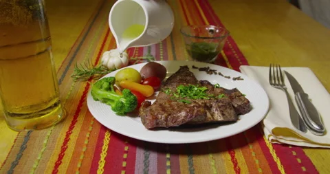 Steak Dinner And Oil Being Poured On Vegetables Stock Footage 243425967