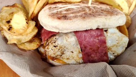 Steak, egg and bacon burger with chips Stock Photos
