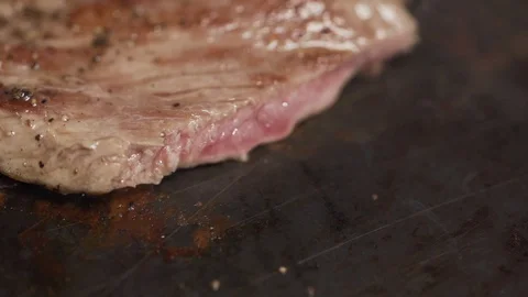 Steak filet being cooked and seasoned on a cooking plate macro shot Video stock 128823820