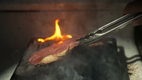 Steak flipped on flat top slow motion dirty stove Video stock 152798807