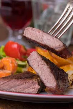 Steak on a fork with vegetables Stock Photos