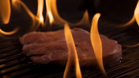 Steak is fried on fire, cooking raw meat on an open fire Stock Footage 116591551