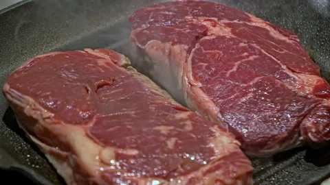 Steak in a frying pan close-up. Red meat steak is fried in a pan. Marble beef in Stock Footage 205094098