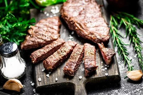 Steak grill on a cutting board with rosemary. Stock Photos