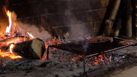 Steak on grill in a fireplace with fire. Stock Footage 95779993