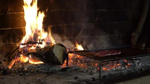 Steak on the grill in a fireplace with lit fire. Stock Footage 91599033