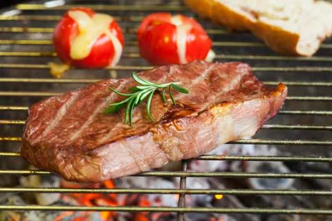 Steak on the grill with tomato Stock Photos