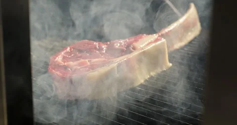 Steak grilling on barbecue grid. Roasting tomahawk steak on barbecue grill Stock Footage 274584371