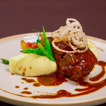 Steak with mashed potatoes and vegetables served on the restaurant table. E.. Fotos de archivo