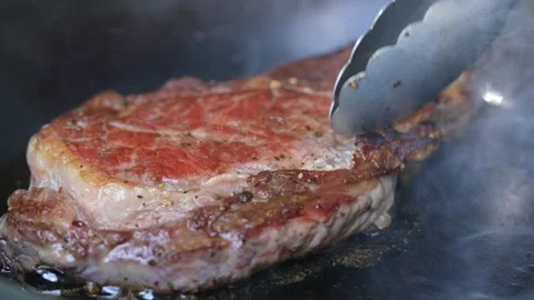 Steak meat beef being grilled on a sizzling hot plate pan with smoke. Stock-Footage 170316845