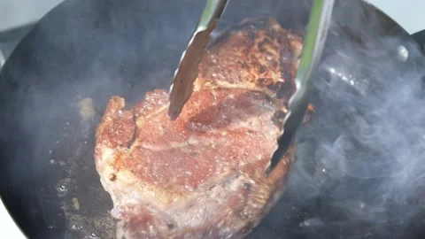 Steak meat beef being grilled on a sizzling hot plate pan with smoke. Stock Footage 170317084