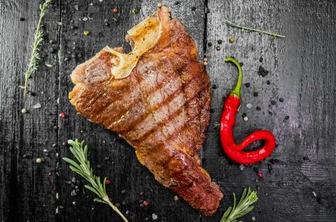 Steak meat on bone with red pepper Stock Photos