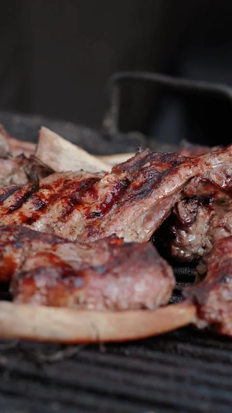 Steak meat is fried on fire and smoke. Barbecue grill with smoke on coals Stock Footage 322790901