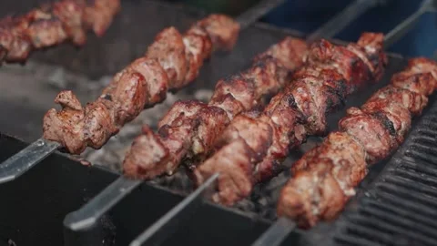 Steak meat is fried on fire and smoke. Barbecue grill with smoke on coals Stock Footage 323093765