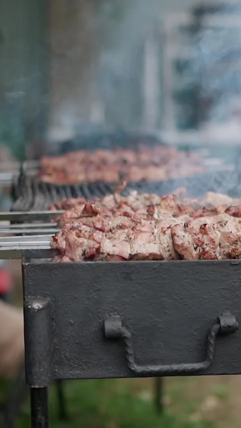 Steak meat is fried on fire and smoke. Barbecue grill with smoke on coals Stock Footage 323093883