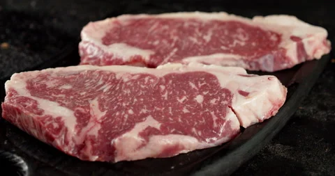Steak raw beef striploin on a cutting board rotates. Stock Footage 139544736