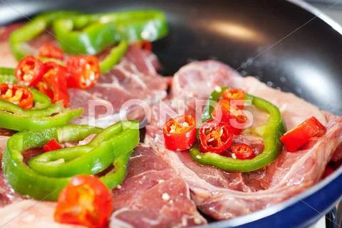 Steak with red and green peppers in a pan Stock Photos