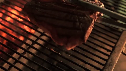Steak T-Bone marbled beef. The chef turns a piece of meat on the grill grill Vídeo Stock 107675000