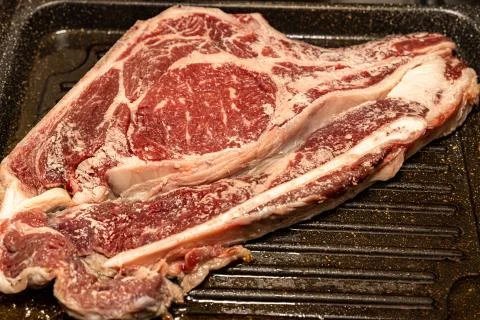Steak tomahawk fried on a grill pan Stock Photos