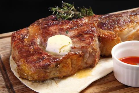Steak Tomahawk  roast on a wooden board with sauce and salt. Stock Photos