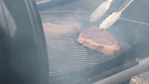 The steak is turned over on the grill. Video stock 181450021