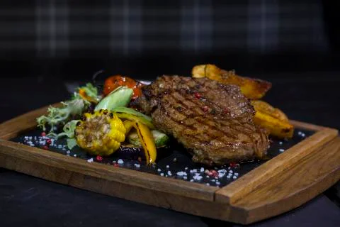 Steak with vegetables. Medium roast meat steak from pork, beef on the board Foto stock