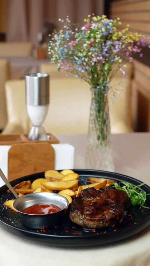 Steak with vegetables on a rotating plate, serving the finished dish. restaurant Stock Footage 310350154