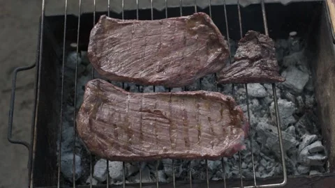 Steaks are cooked on a grill over a fire Stock Footage 131779429
