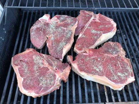 Steaks on a bar -b-que Stock Photos