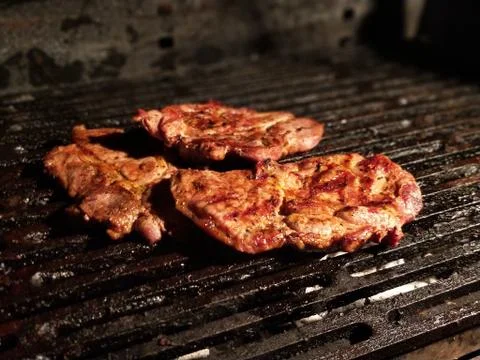 Steaks on barbecue close-up Stock Photos