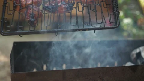 Steaks in a closed grill are fried on the grill. the smoke from the coals. the Video stock 162412559