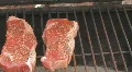 Steaks cooking on charcoal grill Clip 1 HD Footage