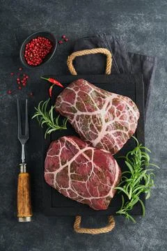 Steaks Raw. Raw cowboy steak, marbled beef meat with spices rosemary and pepp Stock Photos
