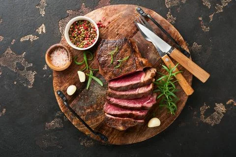 Steaks. Sliced grilled meat steak New York or Striploin with spices rosemary  Stock Photos