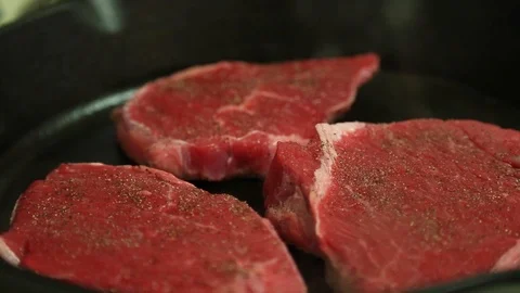Steaks smoke while cooking in a hot cast iron pan Stock Footage 123988136