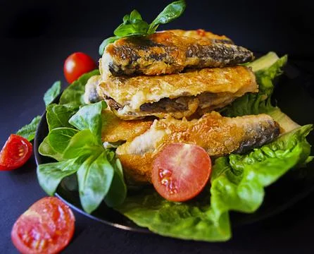 Steaksfried fish  with lettuce and cherry tomatoes on a dark background food pho Stock Photos