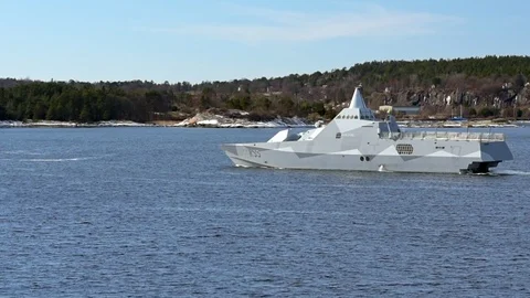 Stealth corvette in archipelago Stock Footage 87390809